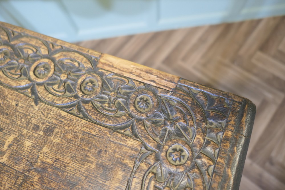A dark oak rectangular occasional table with hand-carved Celtic knotwork detailing, a relief carved apron, turned legs, and lower stretchers. View X