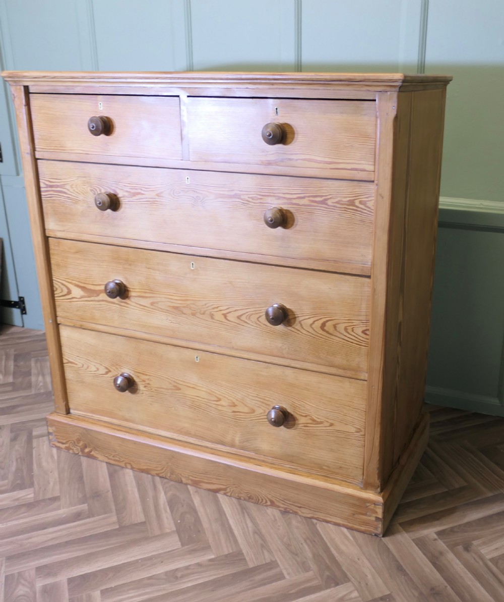 A Victorian stripped pine chest of drawers in a two-over-three arrangement with turned wooden knobs and a solid plinth base. View III