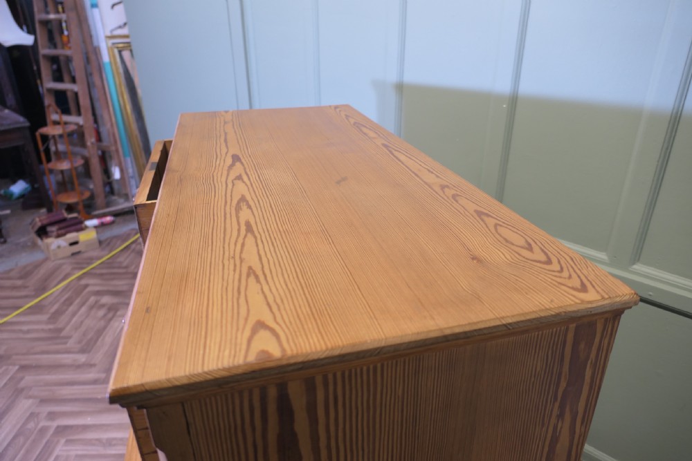 A Victorian stripped pine chest of drawers in a two-over-three arrangement with turned wooden knobs and a solid plinth base. View VIII