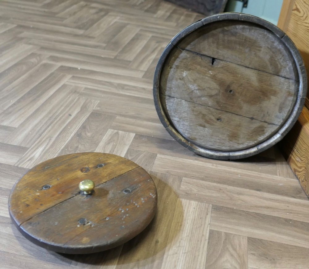 A cylindrical staved oak grog tub bound with three brass bands and fitted with a flat wooden lid with a central brass finial. View V