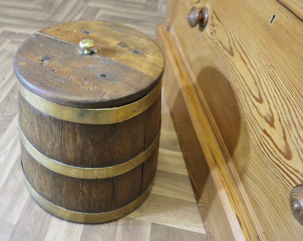 A cylindrical staved oak grog tub bound with three brass bands and fitted with a flat wooden lid with a central brass finial. View VI