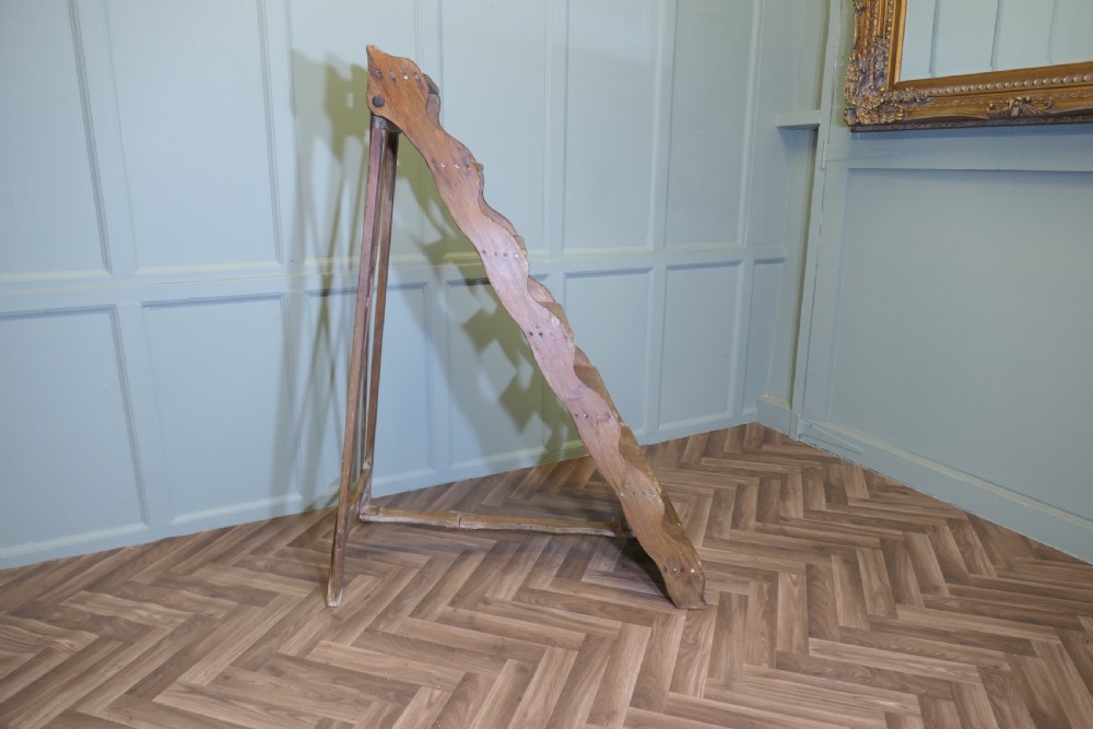 A nineteenth-century folding pine step ladder featuring scalloped wooden side supports and aged timber treads.