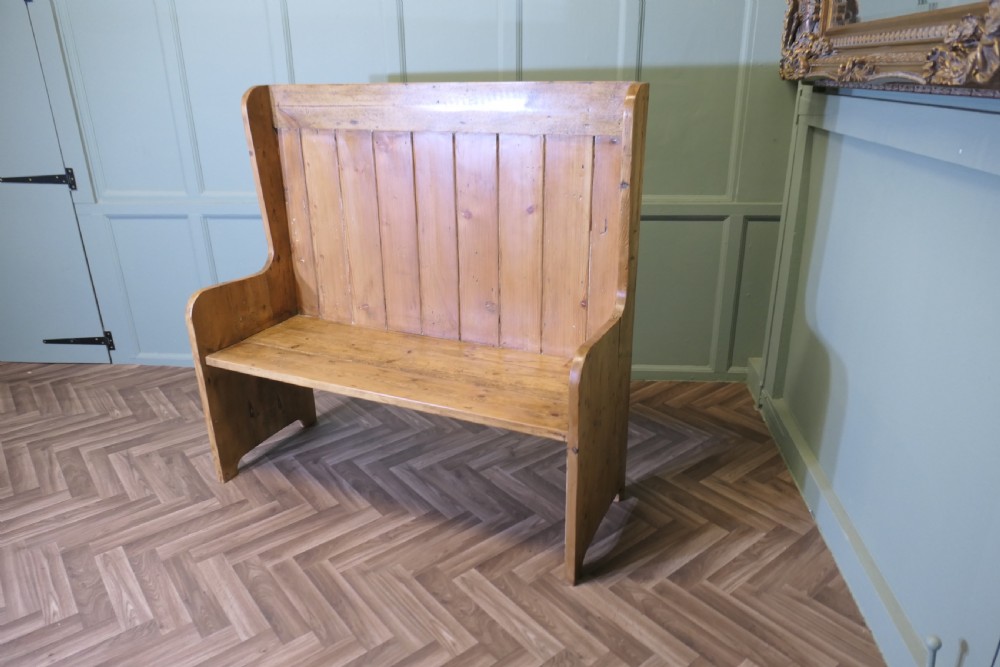 A high-back rustic pine settle bench featuring vertical planking and solid side panels in a natural honey wood finish. View II
