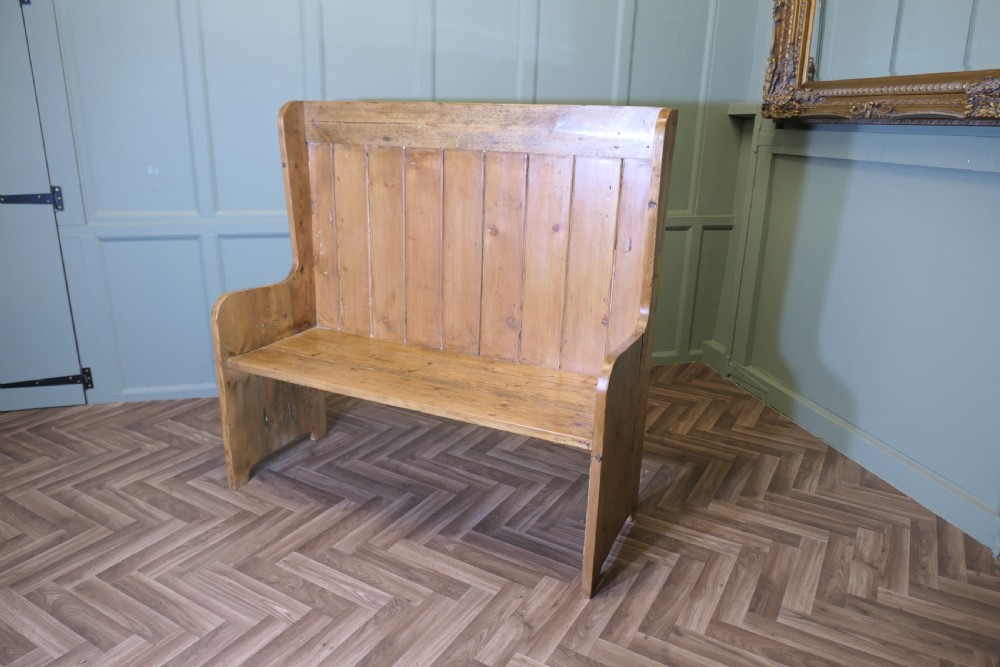 A high-back rustic pine settle bench featuring vertical planking and solid side panels in a natural honey wood finish. View V