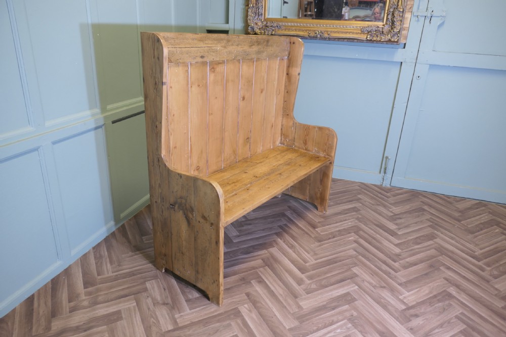 A high-back rustic pine settle bench featuring vertical planking and solid side panels in a natural honey wood finish. View VI
