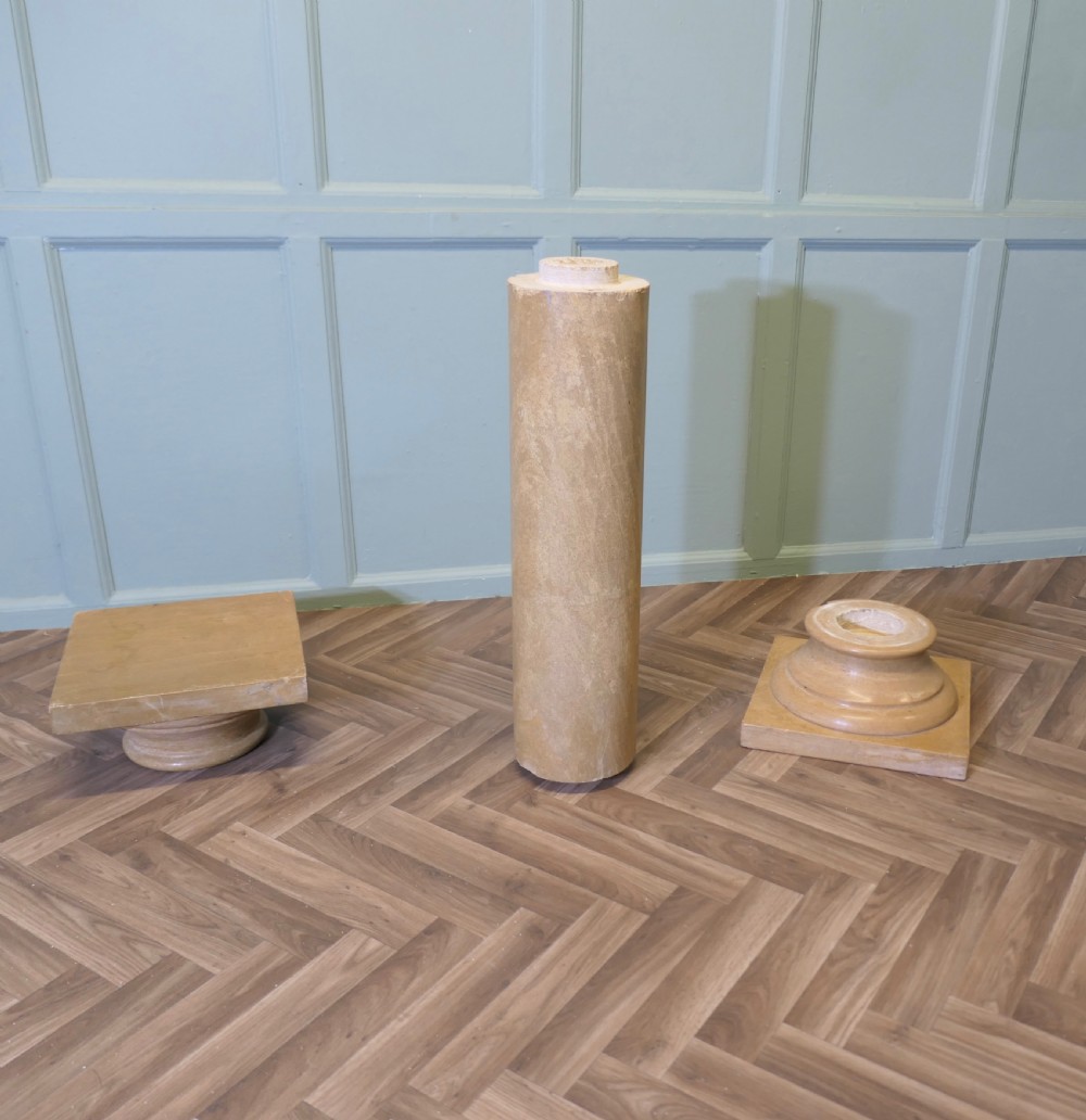 A tall honey-coloured marble column pedestal with a square top platform, cylindrical turned shaft, and square plinth base. View III