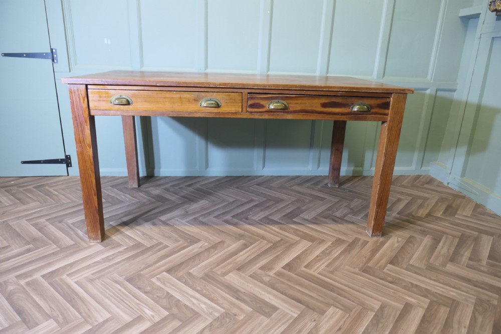 A rectangular antique pine writing table featuring two front drawers fitted with brass cup handles and supported by four straight square legs. View II