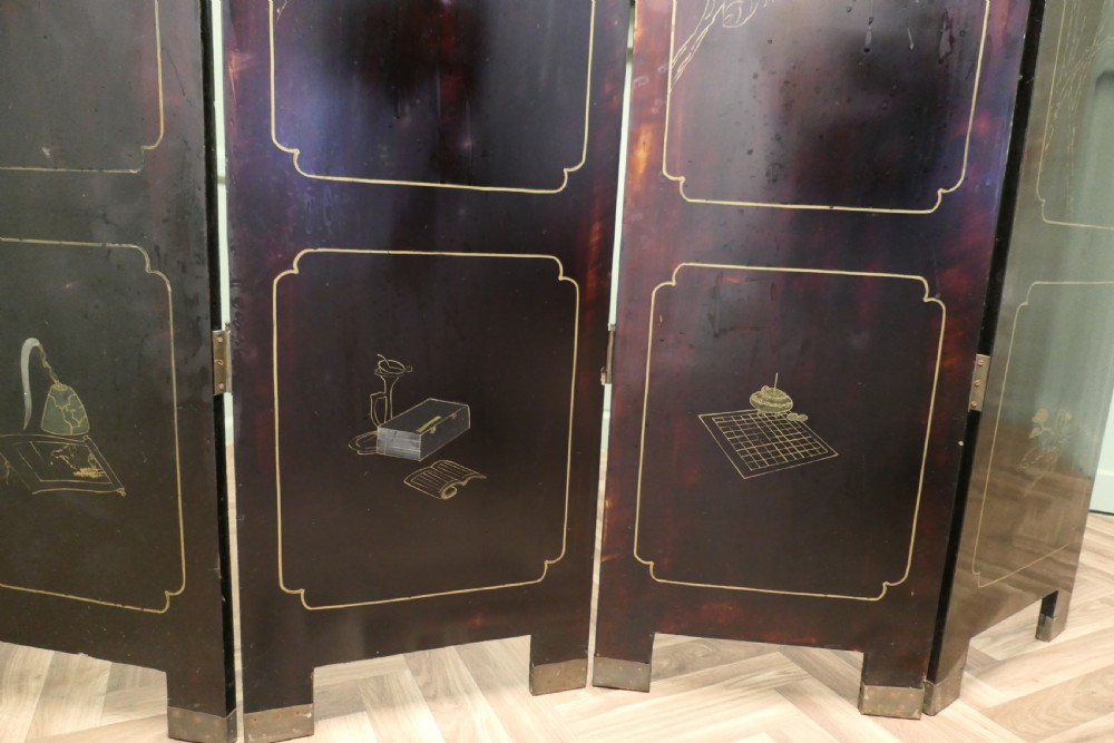 A four-panel black lacquer folding screen decorated with gilt borders and inlaid polychrome relief figures depicting Japanese figures and garden scenery. View IV