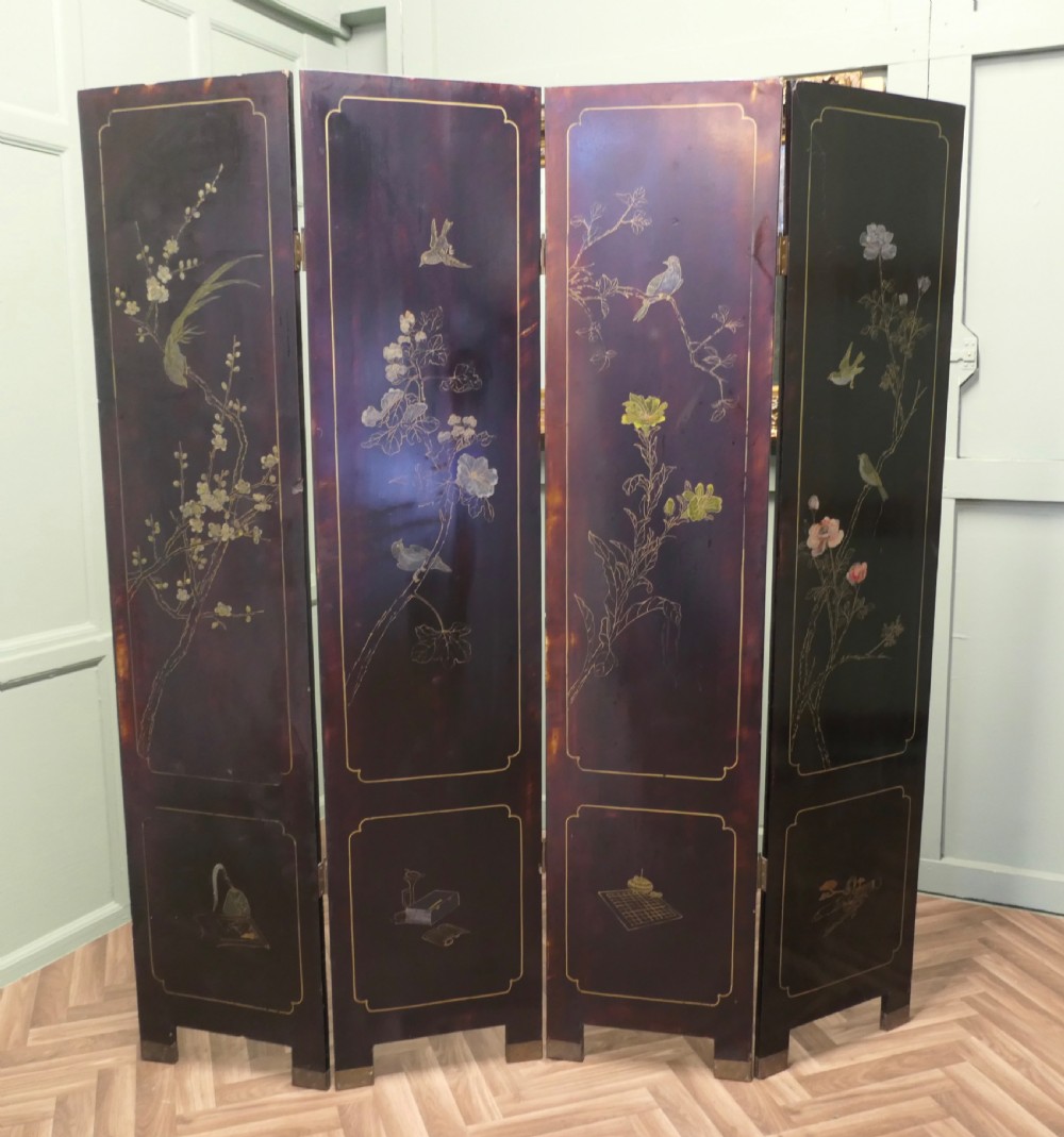 A four-panel black lacquer folding screen decorated with gilt borders and inlaid polychrome relief figures depicting Japanese figures and garden scenery. View III