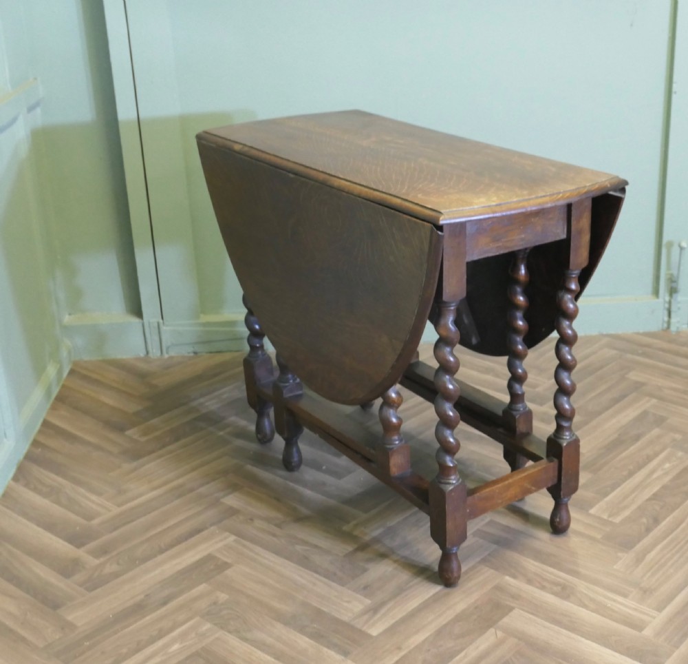 A late nineteenth-century oak gateleg dining table featuring drop-leaf sides and barley twist legs.