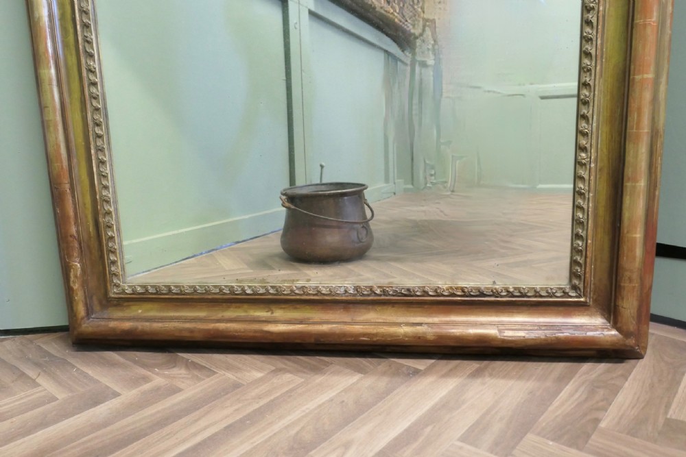 A tall 19th-century French Louis Philippe wall mirror featuring a rounded upper frame with worn antique gold gilding and a beaded inner border. View II