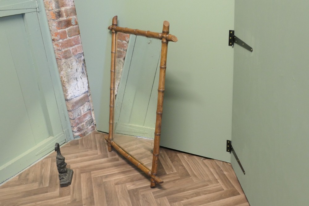 A rectangular French wall mirror featuring a natural bamboo frame with crossed corner joints. View II