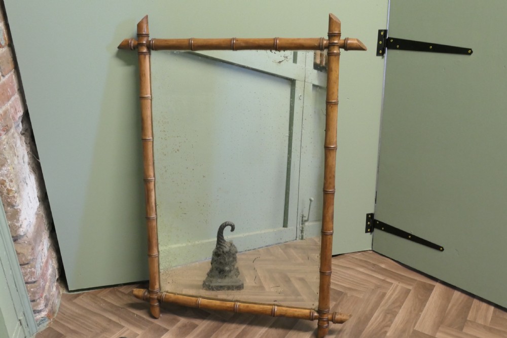 A rectangular French wall mirror featuring a natural bamboo frame with crossed corner joints. View III