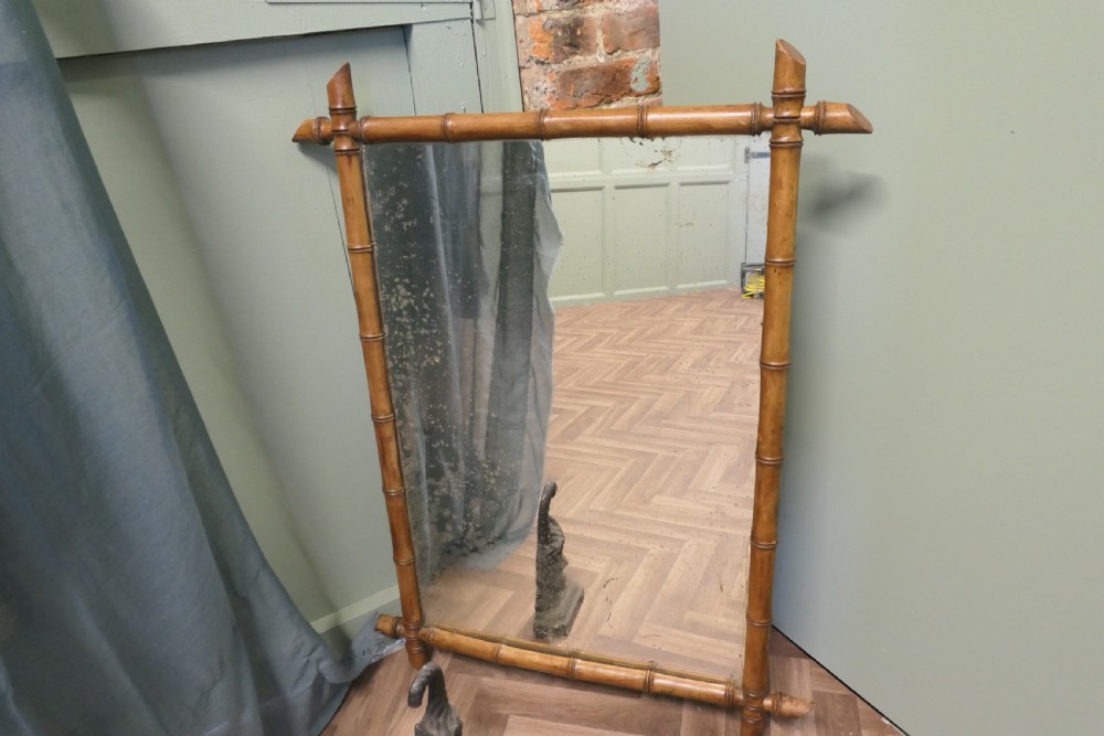 A rectangular French wall mirror featuring a natural bamboo frame with crossed corner joints. View VI