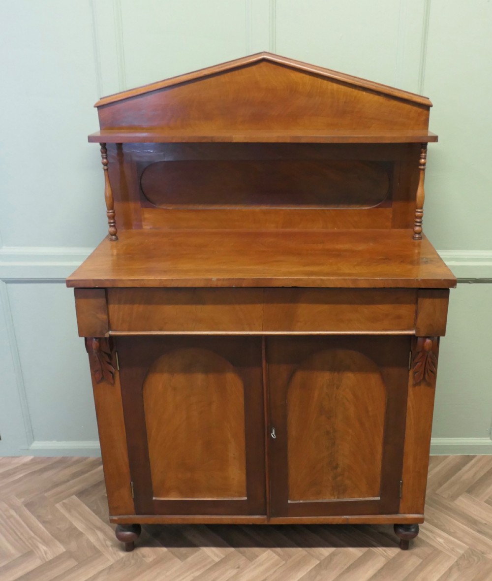 A Victorian mahogany chiffonier featuring a pedimented backboard with a shelf, turned supports, twin arched panel doors, and bun feet. View II