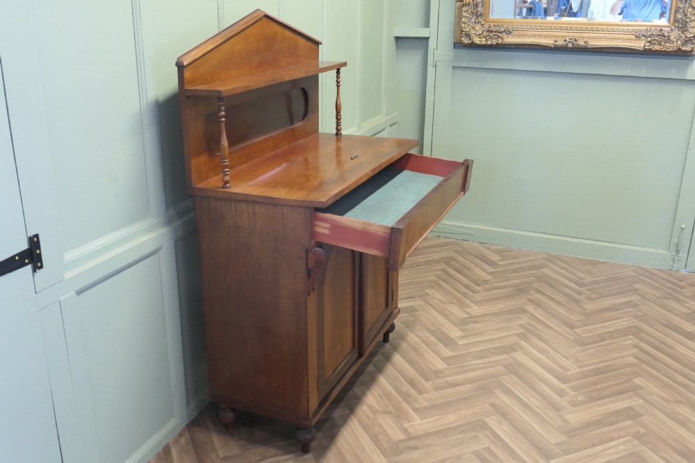 A Victorian mahogany chiffonier featuring a pedimented backboard with a shelf, turned supports, twin arched panel doors, and bun feet. View V