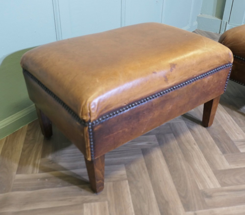 A pair of rectangular tan leather library footstools with close-studded trim detailing on tapered square wood legs. View IV