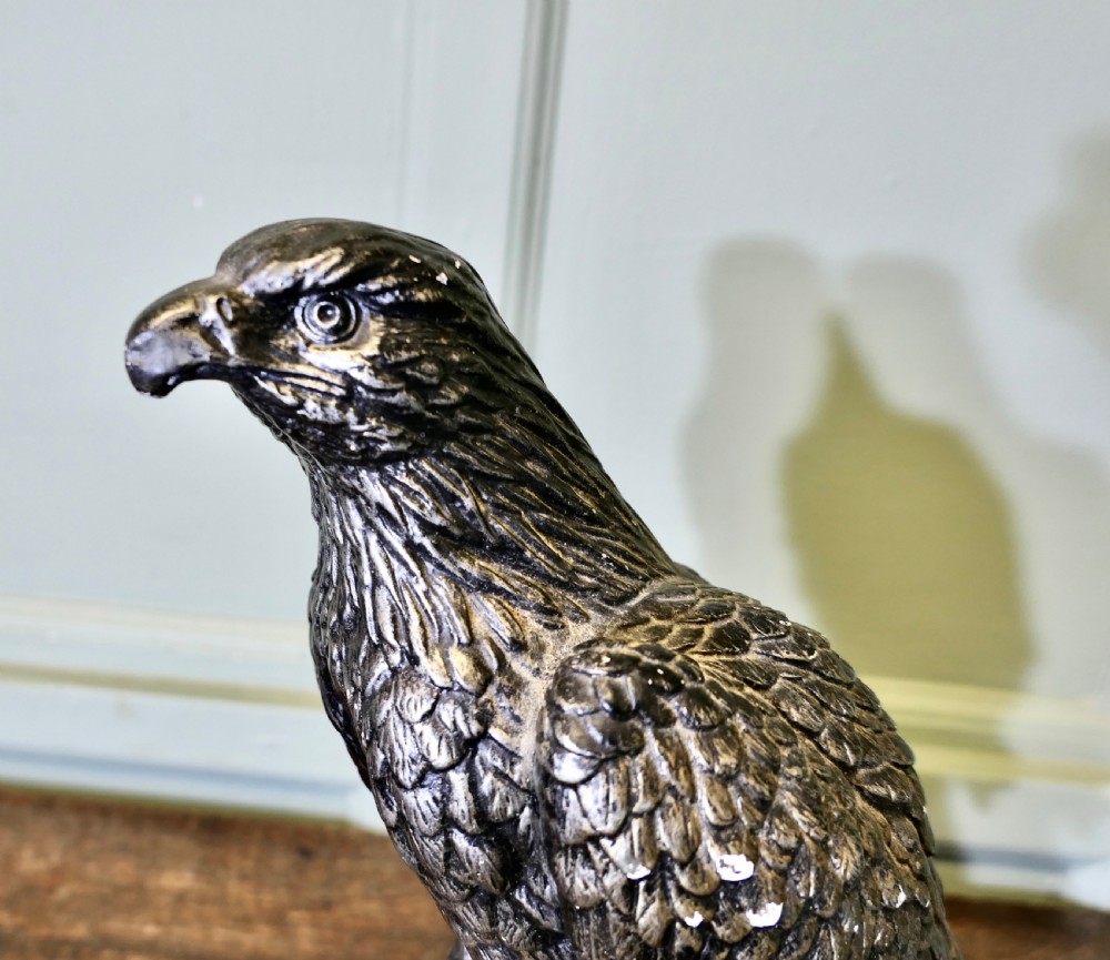 A painted plaster eagle sculpture with a metallic pewter finish perched on a mould base and black pedestal. View VII