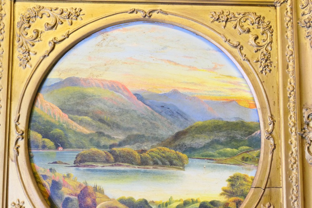 A Victorian oil landscape painting depicting mountains and a lake, set inside a circular aperture framed by a heavy square gilded gesso frame. View II