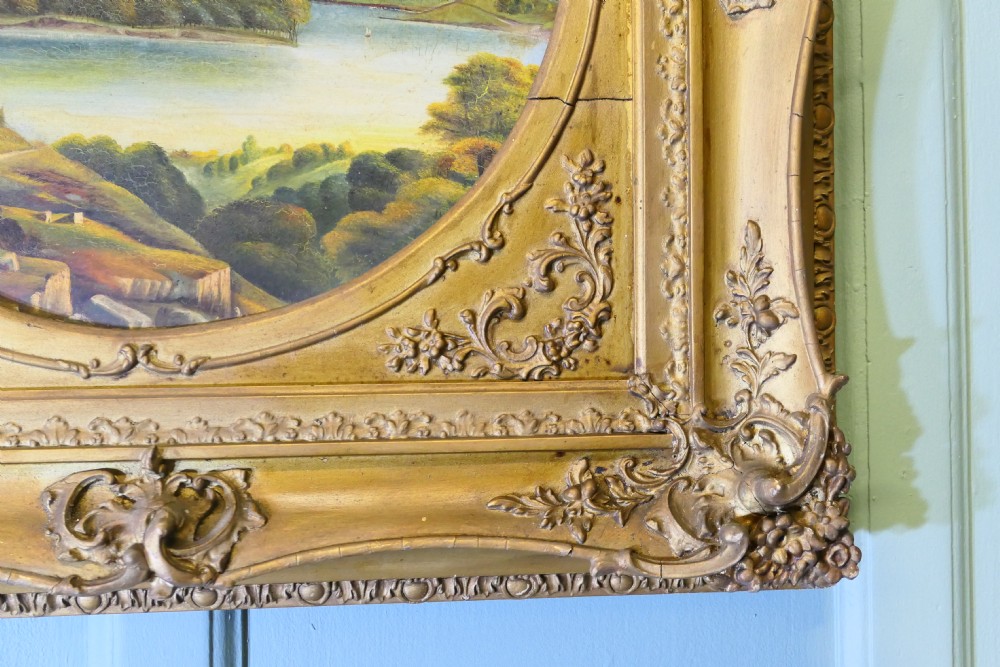 A Victorian oil landscape painting depicting mountains and a lake, set inside a circular aperture framed by a heavy square gilded gesso frame. View IV