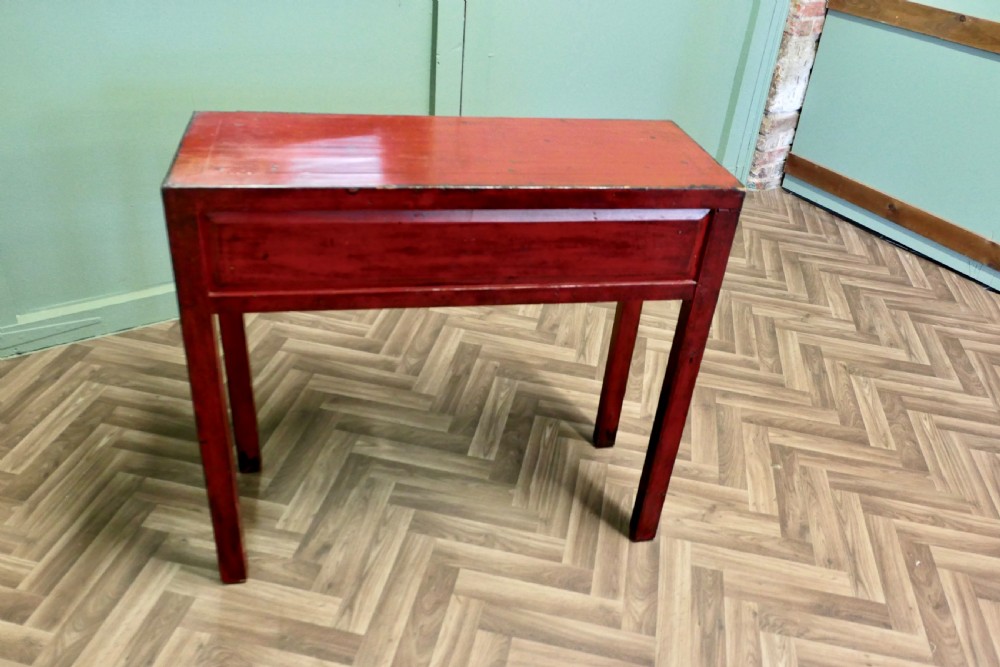 A red lacquered rectangular console table featuring two dark drawers decorated with painted floral motifs and metal ring handles on square legs. View VII