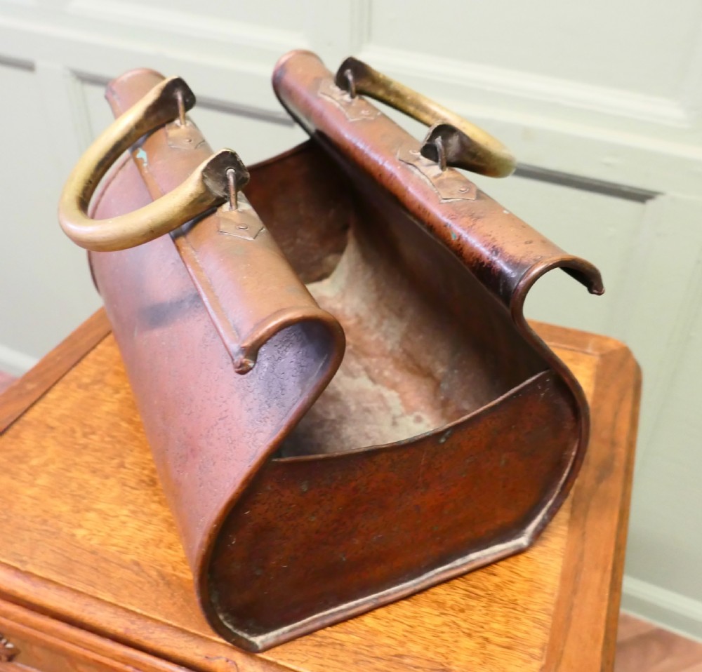 An antique Arts and Crafts copper planter formed in the shape of a Gladstone bag with brass loop handles. View IV