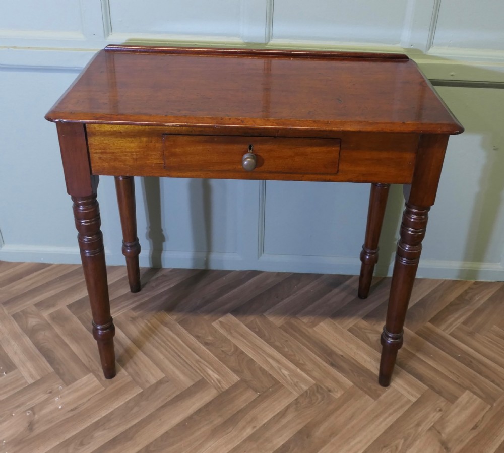A small Victorian mahogany hall table featuring a rectangular top with a raised rear edge, turned legs, and an open side drawer displaying dovetail joinery. View II