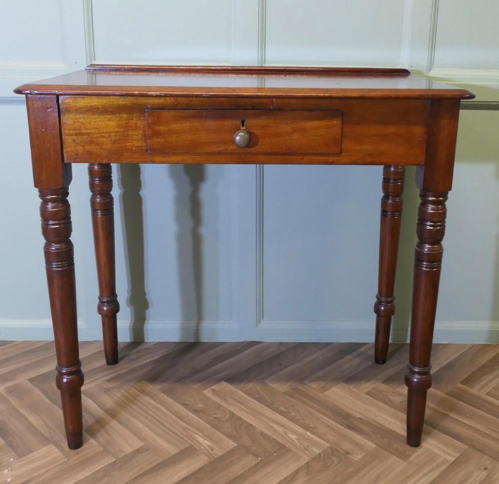 A small Victorian mahogany hall table featuring a rectangular top with a raised rear edge, turned legs, and an open side drawer displaying dovetail joinery. View III