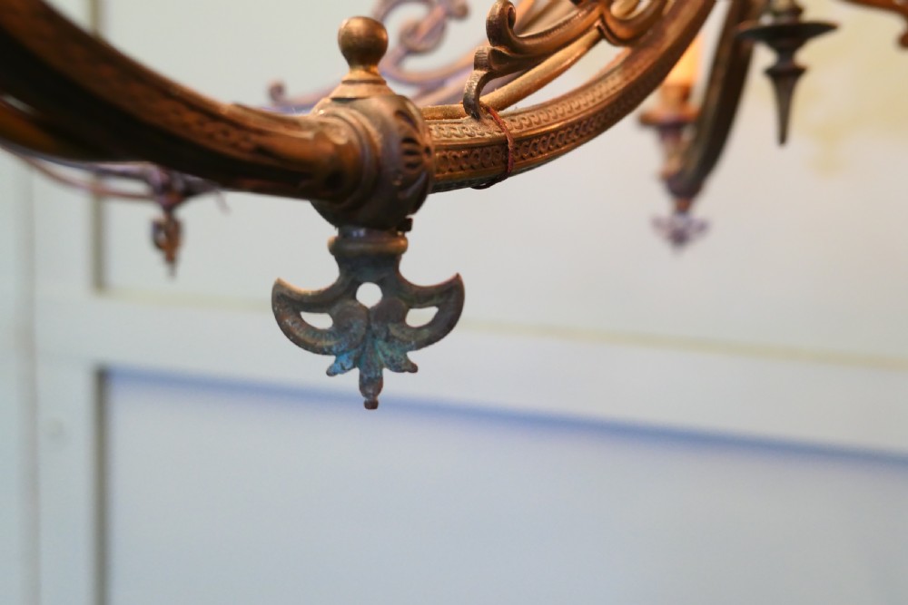 A five-branch gilded brass chandelier featuring Gothic revival openwork tracery, scrolling arms, and candle-style bulb holders. View IV