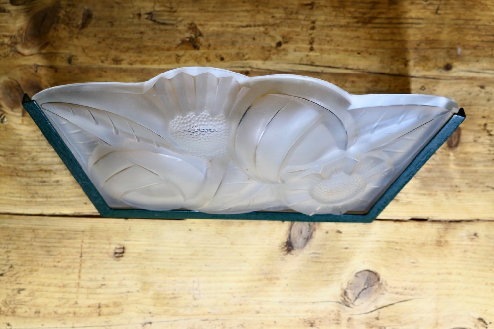 A French Art Deco frosted glass wall light shade featuring press-moulded relief details of stylized flowers and foliage set within a dark metal frame. View II
