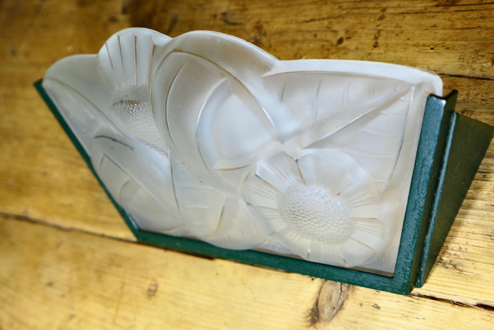 A French Art Deco frosted glass wall light shade featuring press-moulded relief details of stylized flowers and foliage set within a dark metal frame. View IV