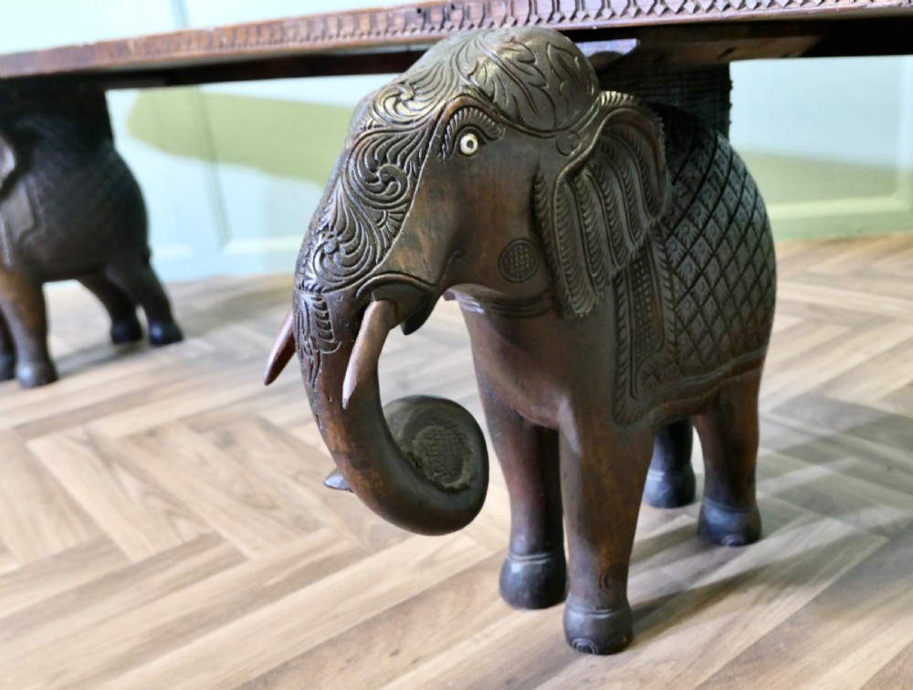 A dark carved wood hall bench featuring a flat rectangular top supported by two detailed elephant figures with raised trunks. View VI