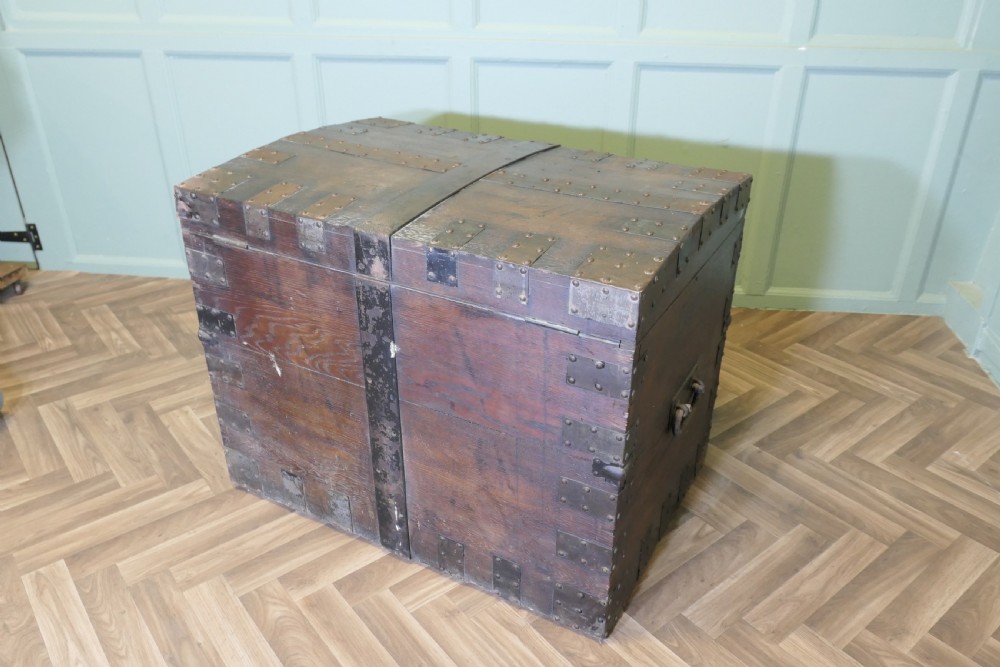 A 19th-century dark oak silver chest reinforced with riveted iron bands, corner brackets, side handles, and a front iron latch. View VI