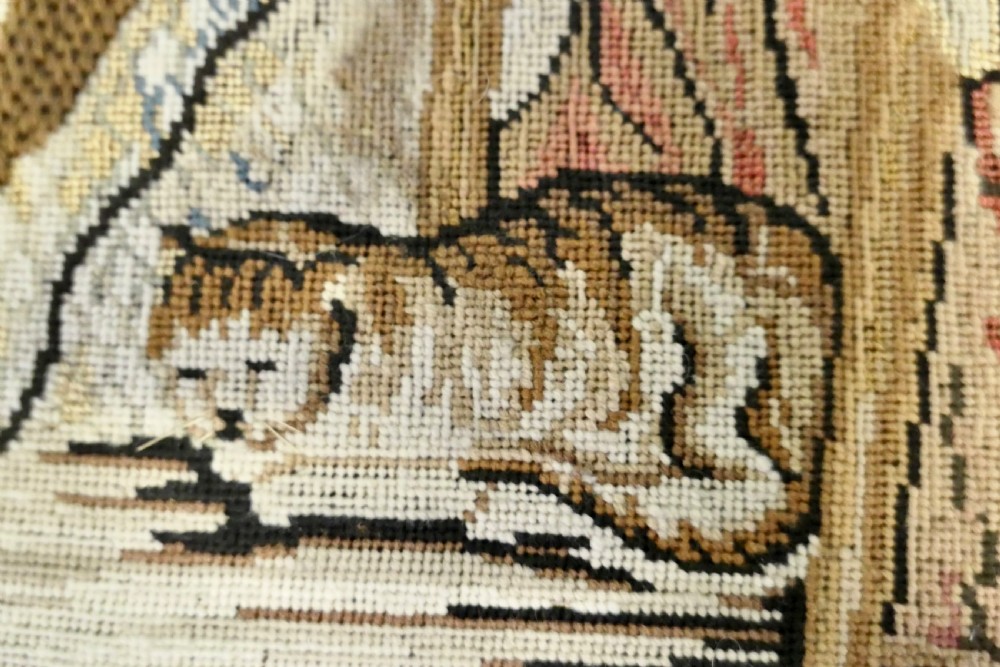 A framed early nineteenth-century wool needlework depicting a classroom scene with a seated teacher, children, and cats. View III