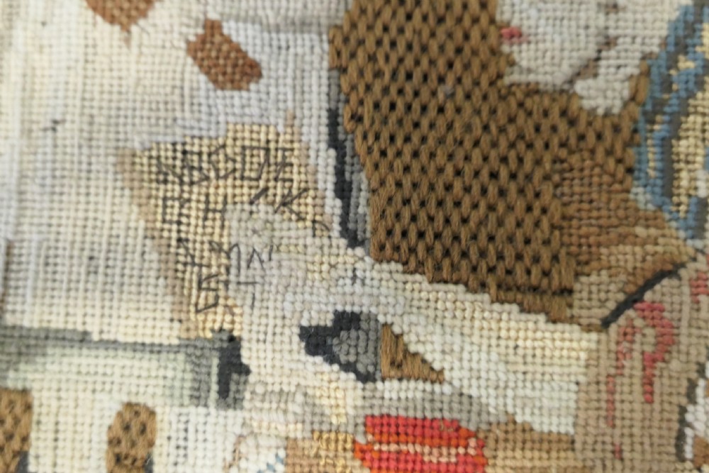 A framed early nineteenth-century wool needlework depicting a classroom scene with a seated teacher, children, and cats. View VI