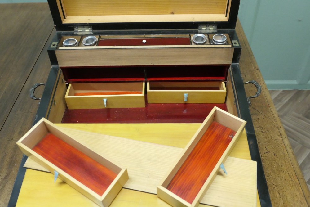 An opened 18th-century satinwood writing slope displaying a green baize writing surface, internal pen tray, glass inkwells, and attached candle sconces. View III