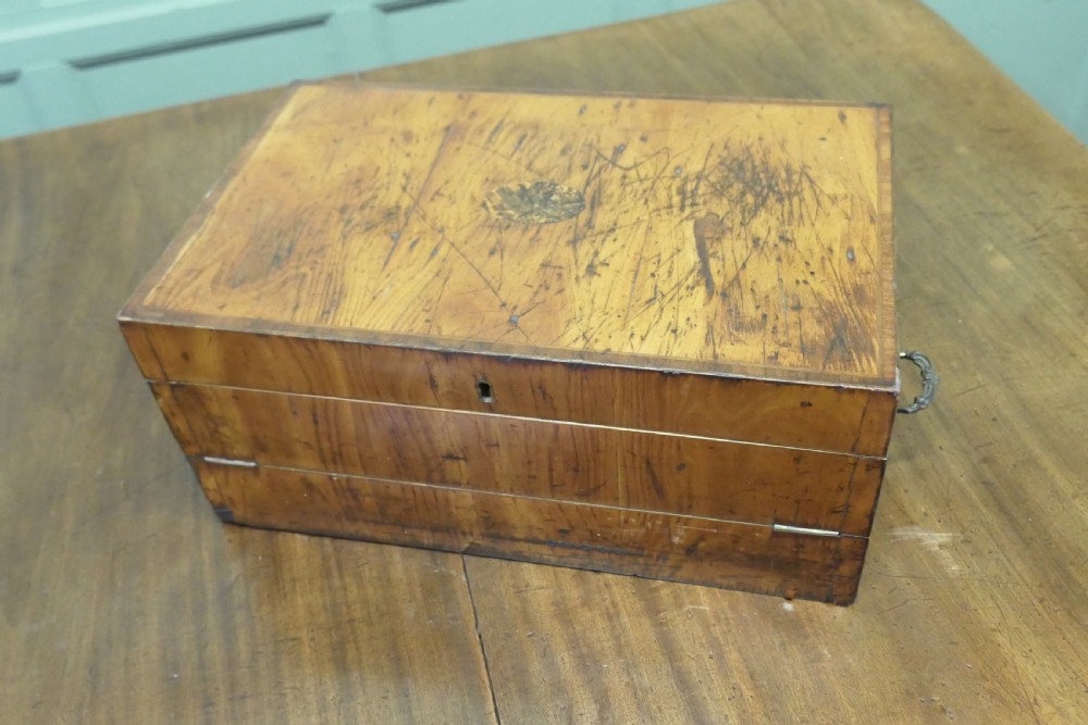 An opened 18th-century satinwood writing slope displaying a green baize writing surface, internal pen tray, glass inkwells, and attached candle sconces. View VI