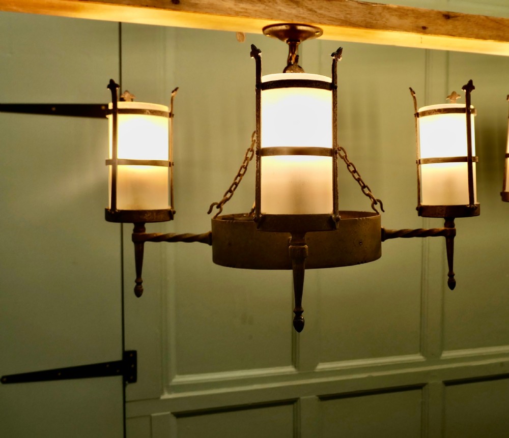 A pair of Arts and Crafts four-arm ceiling lights featuring twisted metal arms, cylindrical frosted shades, and chain suspensions. View II
