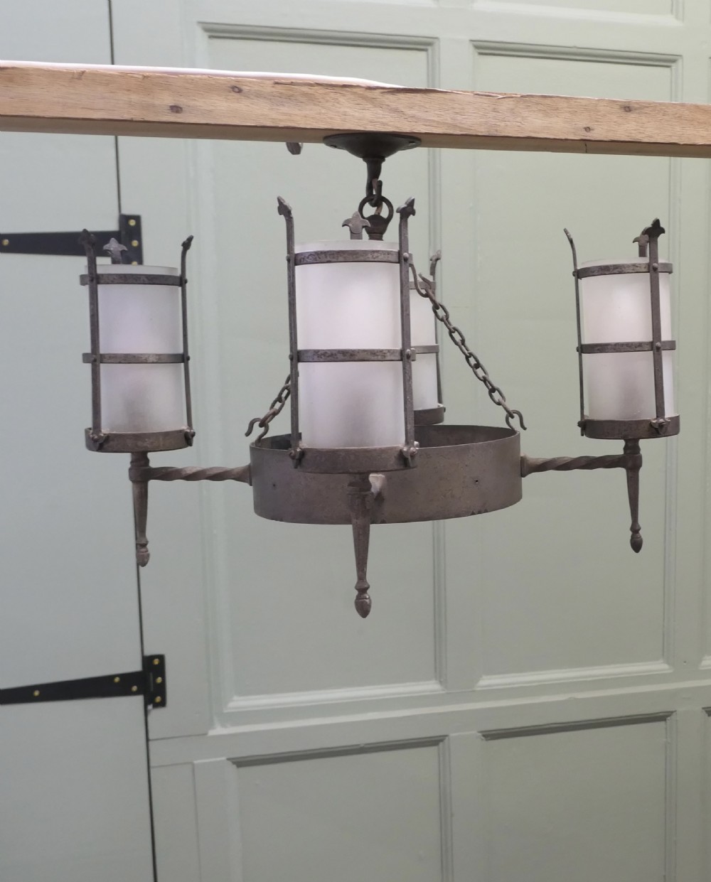 A pair of Arts and Crafts four-arm ceiling lights featuring twisted metal arms, cylindrical frosted shades, and chain suspensions. View III