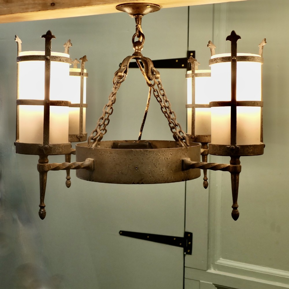 A pair of Arts and Crafts four-arm ceiling lights featuring twisted metal arms, cylindrical frosted shades, and chain suspensions. View VI