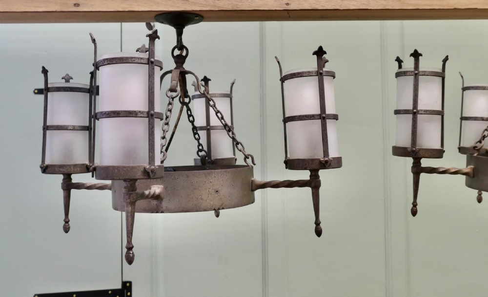 A pair of Arts and Crafts four-arm ceiling lights featuring twisted metal arms, cylindrical frosted shades, and chain suspensions. View VII
