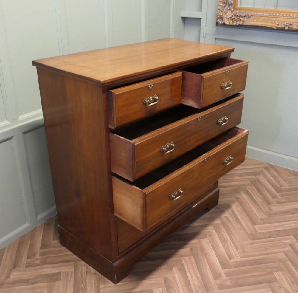 A large Edwardian walnut chest of drawers featuring two short drawers over three long drawers with brass drop handles. View V