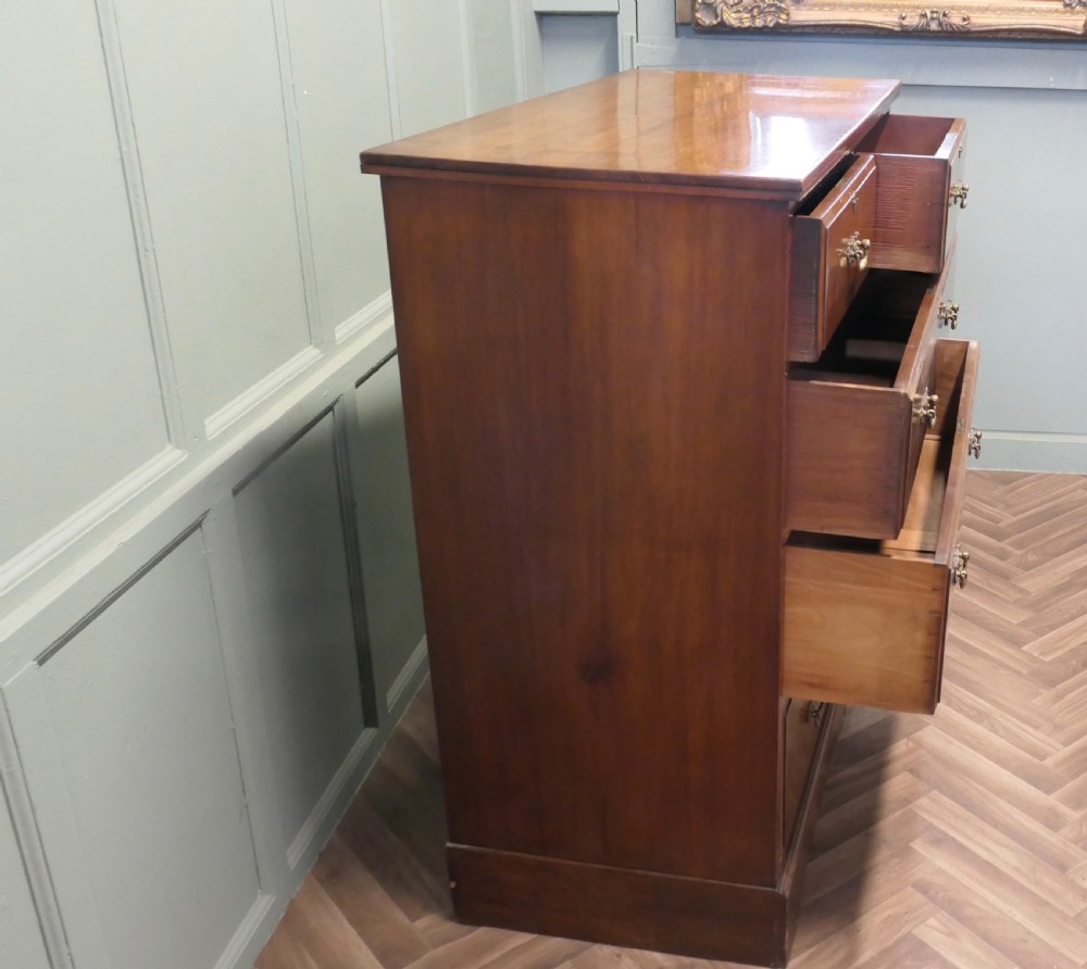 A large Edwardian walnut chest of drawers featuring two short drawers over three long drawers with brass drop handles. View VI