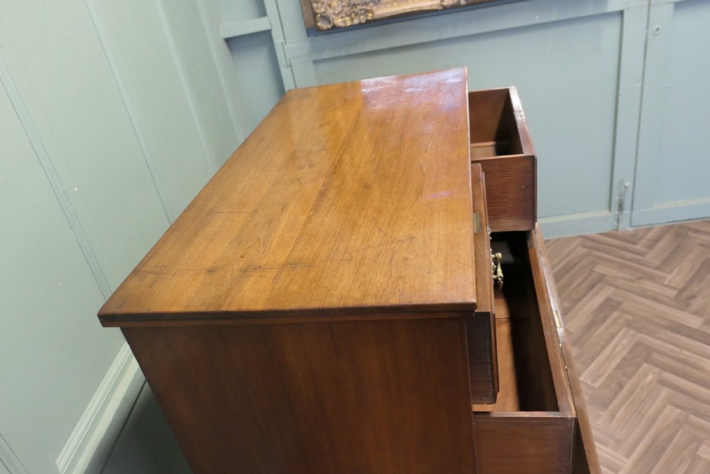 A large Edwardian walnut chest of drawers featuring two short drawers over three long drawers with brass drop handles. View VII