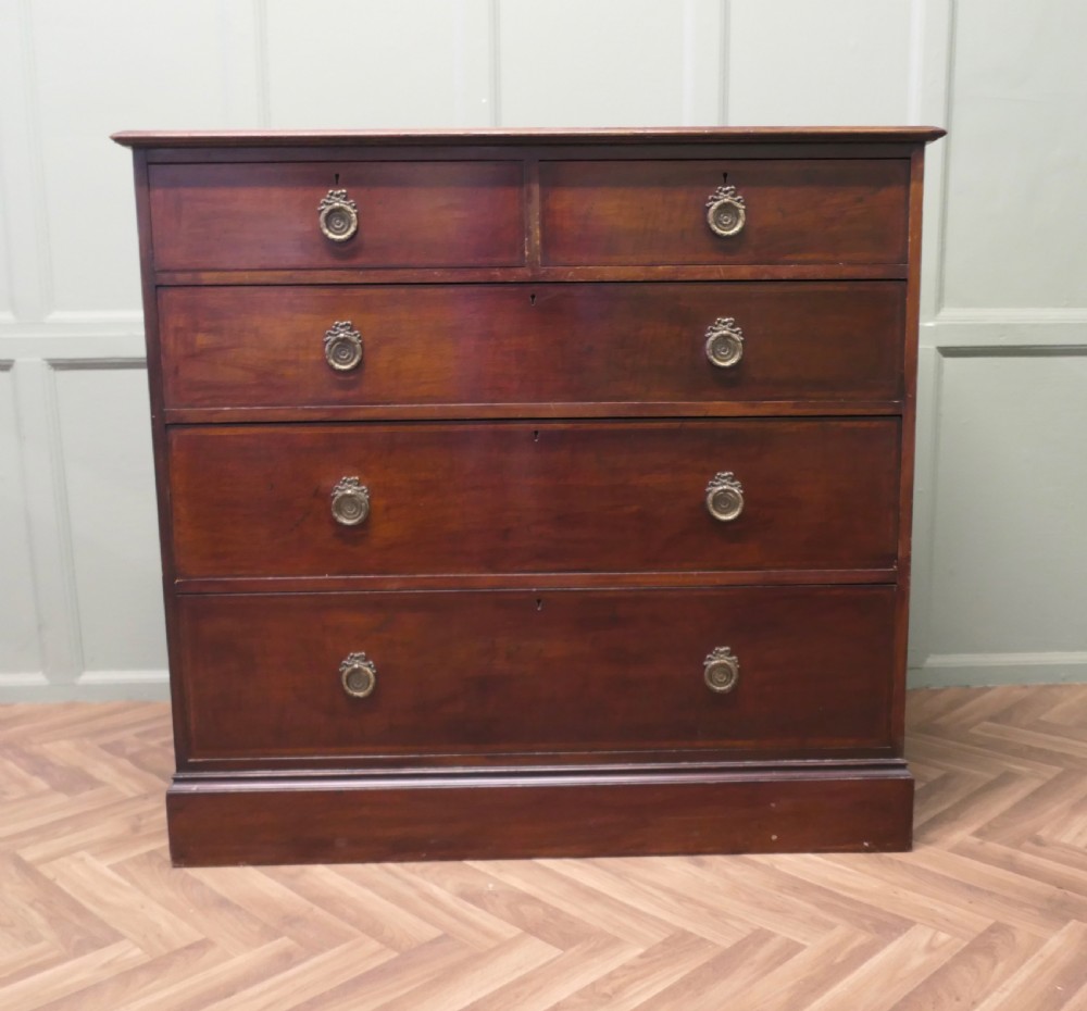 A 19th-century dark mahogany chest of drawers featuring a two-over-three drawer configuration with circular brass ring handles and a solid plinth base.