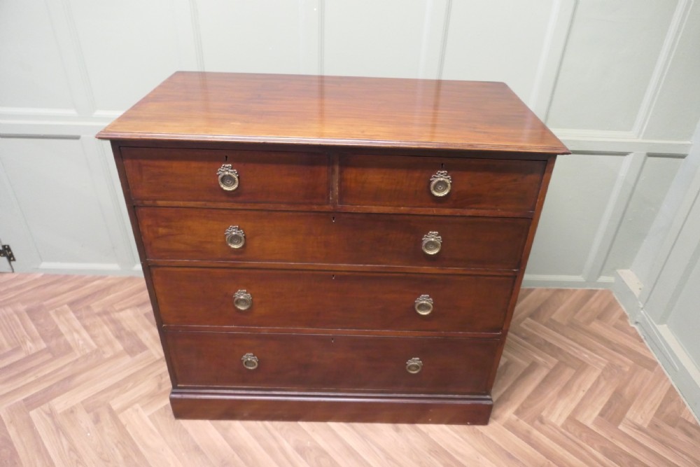 A 19th-century dark mahogany chest of drawers featuring a two-over-three drawer configuration with circular brass ring handles and a solid plinth base. View II