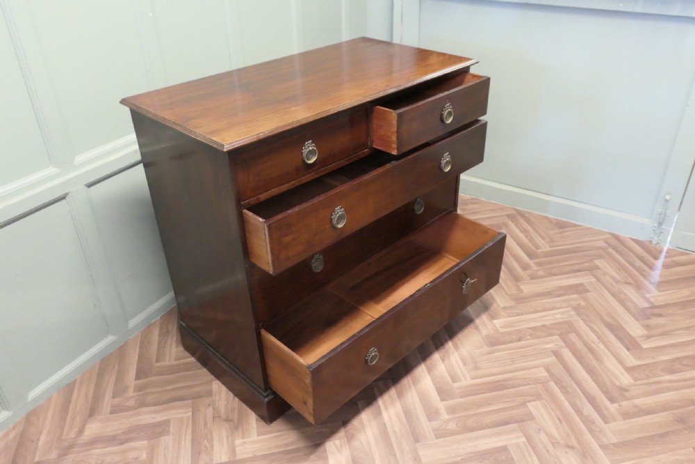 A 19th-century dark mahogany chest of drawers featuring a two-over-three drawer configuration with circular brass ring handles and a solid plinth base. View VII