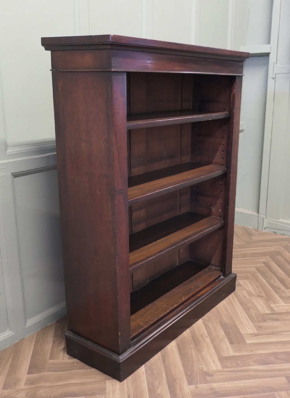 A Victorian dark mahogany open bookcase featuring four adjustable shelves, a simple moulded top cornice, and a sturdy plinth base. View III