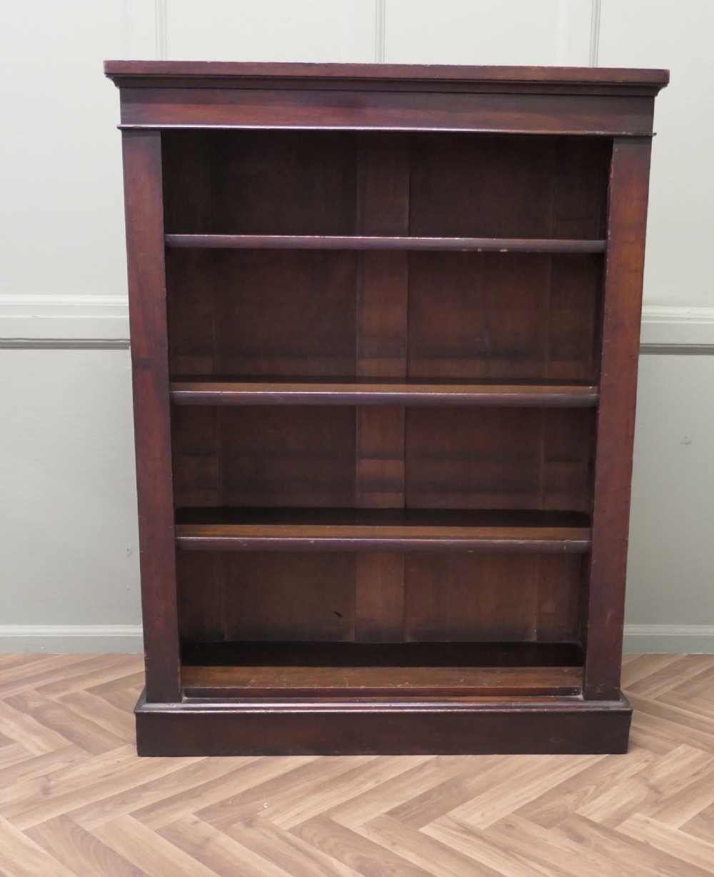 A Victorian dark mahogany open bookcase featuring four adjustable shelves, a simple moulded top cornice, and a sturdy plinth base. View VI