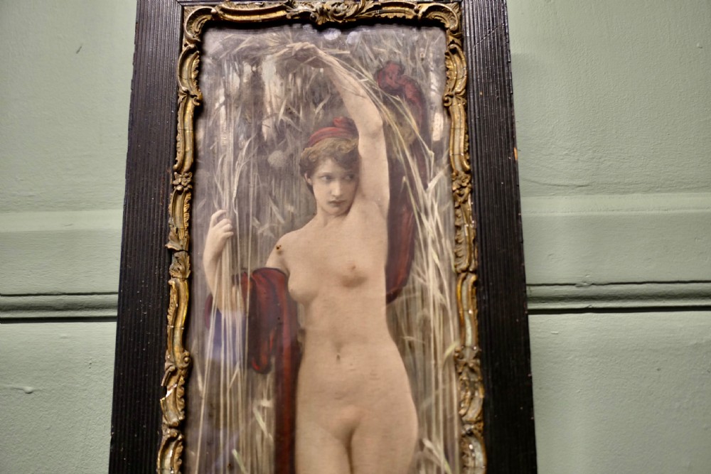 A vertical framed print depicting a classical female figure standing among tall reeds, encased within an ornate gilt inner moulding and a ribbed black timber frame. View II